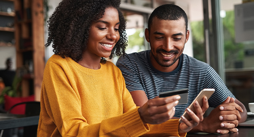 man and woman using a wings platinum card while on phone 520X280