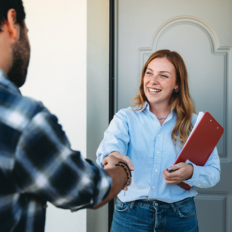 people shaking hands at front door of home