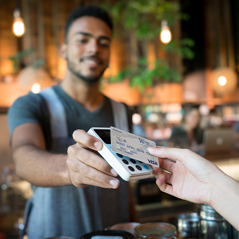 man using a tap to pay card