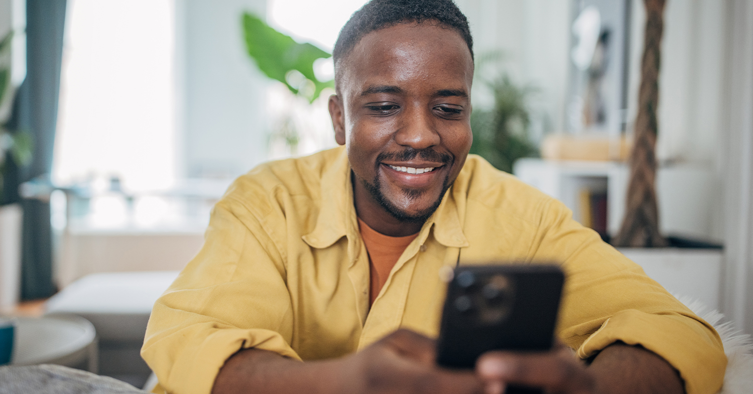 man smiling and looking at his phone_1500x785