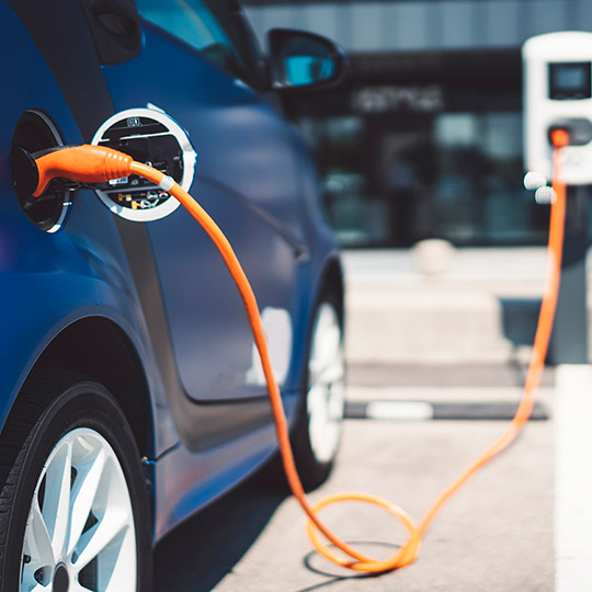 Blue car charging at an electric car charging station