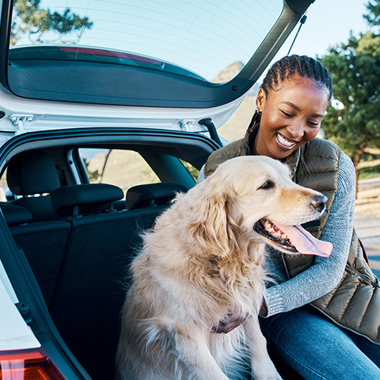 women sitting in her trunk with her dog_540x540