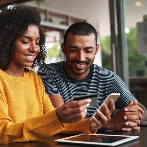 man and woman using a wings platinum card while on phone 480X480