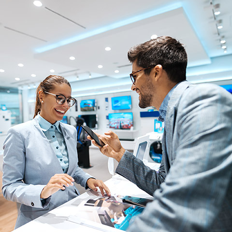 Man in a nice suit holding his phone at a checkout counter to purchase an item