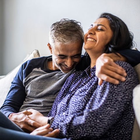 Middle age couple sitting on a couch together