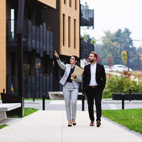 Woman realtor showing client an apartment building